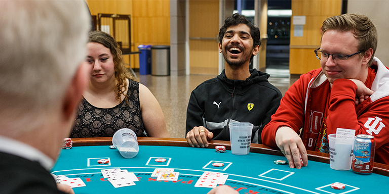 Three students playing poker at a casino event.